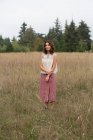 Портрет счастливой семнадцатилетней девушки, стоящей в поле высоких трав — стоковое фото