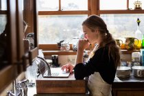 Дівчина-підліток на кухні після рецепту випічки на ноутбуці . — стокове фото