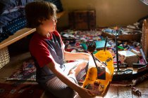 Hochwinkelaufnahme eines kleinen Jungen in seinem Zimmer, der mit seinem Spielzeug spielt — Stockfoto