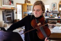 Teenage girl practicing violin at home — Stock Photo
