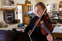 Adolescente che pratica il violino a casa — Foto stock