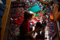 Vista ad alto angolo di giovane ragazzo nella sua stanza a giocare con i suoi giocattoli — Foto stock