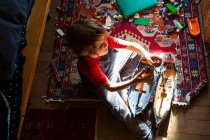 Vue grand angle du jeune garçon dans sa chambre jouant avec ses jouets — Photo de stock
