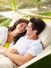 Jovem casal feliz em casa relaxante, compartilhando uma rede — Fotografia de Stock