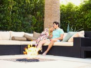 Happy young couple at home, sitting by a firepit outdoors — Stock Photo