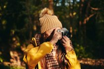Женщина фотографирует с камерой в лесу — стоковое фото