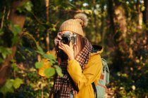 Жінка фотографує з камерою в лісі — стокове фото