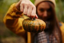 Woman holding up pumpkin to camera — Stock Photo