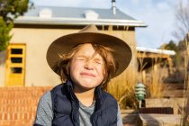 Porträt eines kleinen Jungen mit Fedora-Hut entspannt auf seiner Veranda — Stockfoto