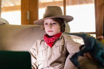 Kleiner Junge im Safari-Outfit und Kopfhörer beim Ansehen eines Films auf dem Laptop — Stockfoto