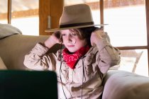 Giovane ragazzo vestito safari e cuffie guardando un film sul computer portatile — Foto stock