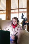 Chico joven con traje de safari y auriculares viendo una película en el ordenador portátil - foto de stock