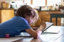 Мальчик отслеживает на своем ноутбуке — стоковое фото