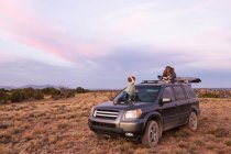 Niños en SUV car at sunset, Galisteo Basin, Santa Fe, NM. - foto de stock