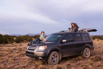 Niños en SUV car at sunset, Galisteo Basin, Santa Fe, NM. - foto de stock