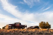 Familia pasar tiempo al lado de un SUV coches, Cuenca Galisteo, Santa Fe, NM. - foto de stock