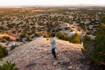 Young boy looking down at Galisteo Basin, Santa Fe, NM. — Stock Photo