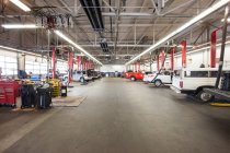 Filas de coches y camiones en taller de reparación de automóviles - foto de stock
