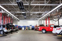 Rangées de voitures et de camions dans l'atelier de réparation automobile — Photo de stock