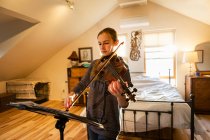 Ragazza adolescente che suona il violino nella sua camera da letto — Foto stock