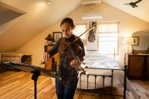 Ragazza adolescente che suona il violino nella sua camera da letto — Foto stock