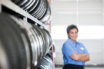 Retrato de mujer mecánica hispana en taller de reparación de automóviles - foto de stock