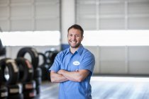 Retrato de um sorridente branco mecânico masculino em uma oficina de reparação de automóveis — Fotografia de Stock
