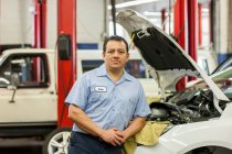Retrato do mecânico masculino hispânico na oficina de reparação de automóveis — Fotografia de Stock