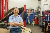 Retrato de mecánico de automóviles de las islas del Pacífico en taller de reparación de automóviles - foto de stock