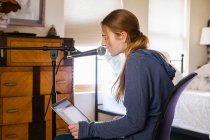Девочка-подросток поет в микрофон в своей спальне — стоковое фото