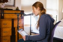 Adolescente cantando em um microfone em seu quarto — Fotografia de Stock
