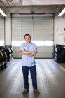 Retrato del propietario masculino hispano en taller de reparación de automóviles - foto de stock