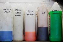 Fluides utilisés dans l'atelier de réparation automobile stand tous dans une rangée — Photo de stock