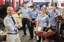 Portrait of smiling auto repair shop team with Pacific Islander owner — Stock Photo