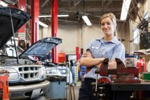 Porträt einer jungen kaukasischen Mechanikerin in der Autowerkstatt — Stockfoto