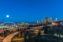 Die Skyline von Seattle bei Nacht, Straße und Brücke, Gebäude in der Innenstadt erstrahlen im Mondlicht. — Stockfoto