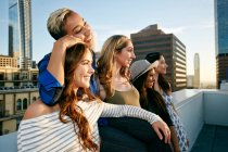Grupo de jovens mulheres festejando em um telhado da cidade ao entardecer — Fotografia de Stock