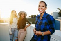 Tre giovani donne su un tetto al tramonto — Foto stock