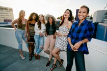Група молодих жінок, що вечірки на міському даху в сутінках — стокове фото