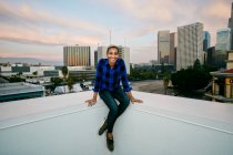 Junge Frau in der Abenddämmerung auf einem Dach der Stadt — Stockfoto