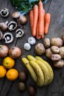 High angle close up of various fruits and vegetables on wooden table — Stock Photo
