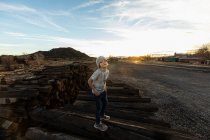 7 anno vecchio ragazzo standing solo su ferrovia cravatte a tramonto — Foto stock