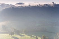 Vista sobre Uley Village em Cotswolds, névoa e nuvens. — Fotografia de Stock