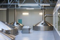Interior de la cervecería, grandes tanques de almacenamiento de acero para la elaboración de cerveza. - foto de stock