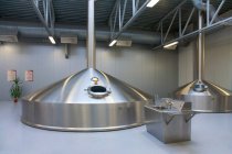 Interior de la cervecería, grandes tanques de almacenamiento de acero para la elaboración de cerveza. - foto de stock
