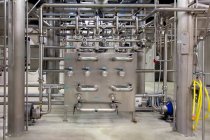 Interior de la cervecería, grandes tuberías de acero, válvulas y unidad de control para el proceso de elaboración de la cerveza - foto de stock