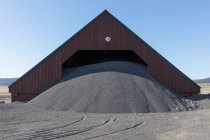 Barn and gravel pile used for road construction and maintenance — Photo de stock