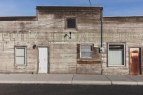 Old wooden building on Main Street, rusted door and boarded up windows. — Fotografia de Stock