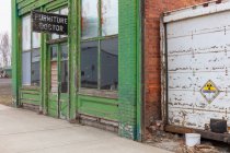 Edificio abandonado en una calle principal, Muebles letrero médico por encima de la puerta principal, taller de reparación - foto de stock