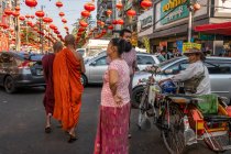 Buddhist monks on busy street in downtown Yangon decorated with red chinese lanterns in preparation for Chinese New Year celebrations Myanmar — Stock Photo